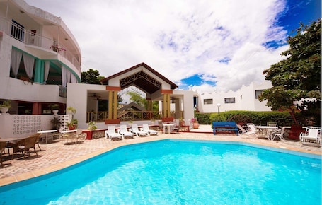 Outdoor pool, pool loungers. Habitation Hatt Hotel