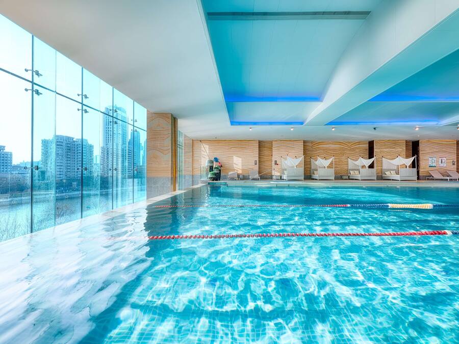 Een binnenzwembad en ligstoelen