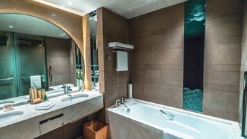 Un baño moderno con dos lavamanos, una bañera grande y un espejo.