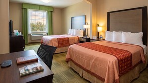 A hotel room with two beds, a desk with a computer, a chair, a TV, and a window with curtains. - Cotulla Express Inn (Cotulla)