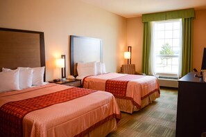 A hotel room with two beds, a desk, a lamp, and a window with curtains. - Cotulla Express Inn (Cotulla)