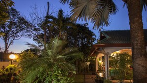 A garden with palm trees and a gazebo. - Ya Nui Resort (Rawai)