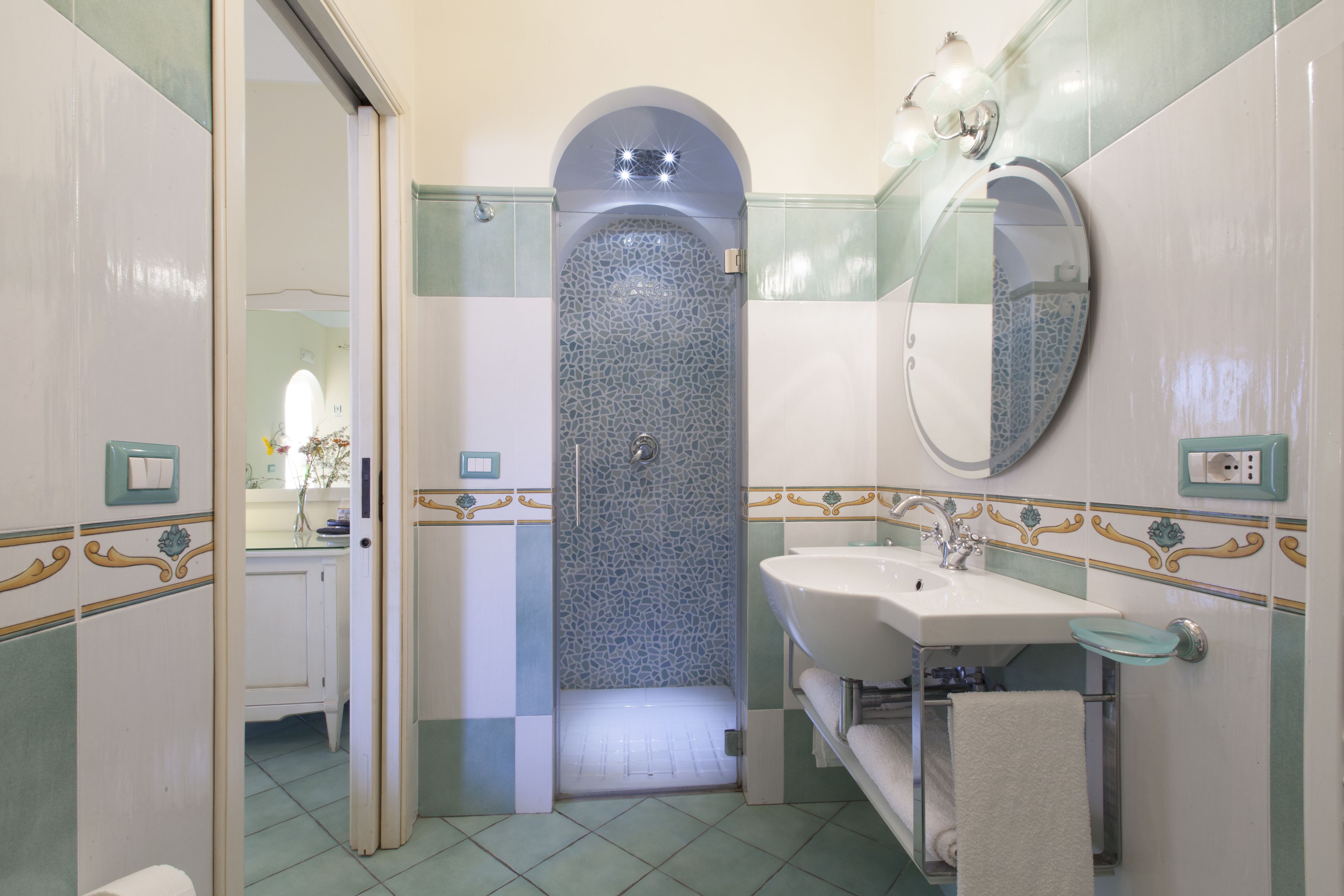 Un baño con ducha, lavabo y espejo.