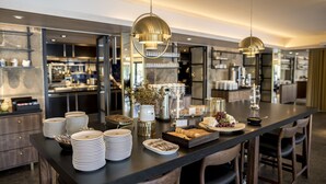 A modern kitchen with a central island, stainless steel appliances, and pendant lighting.