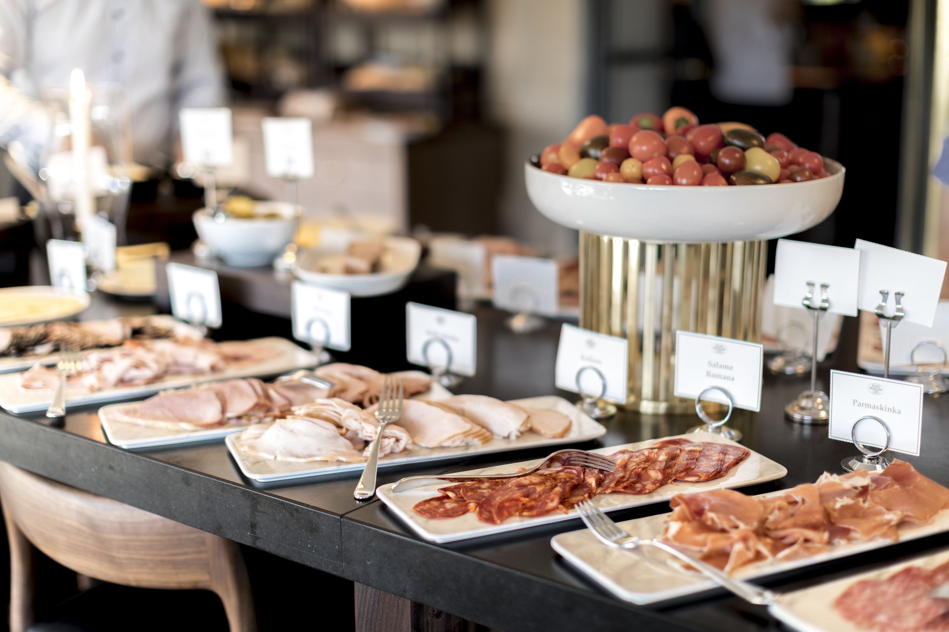 A buffet table with various food items and labels.