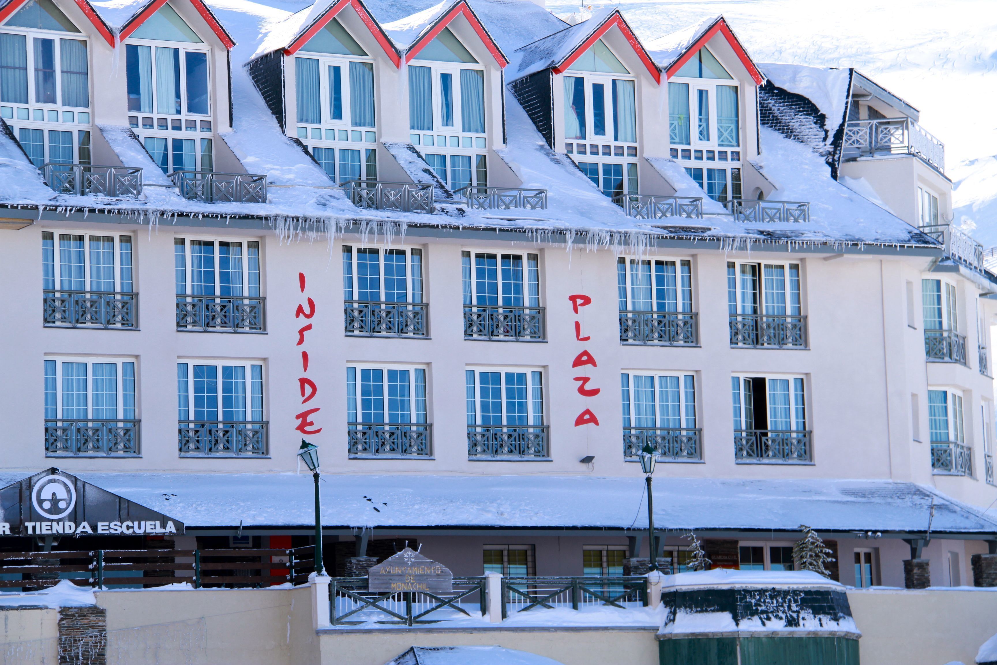 A multi-story hotel with balconies and a sign reading "Inside Plaza."