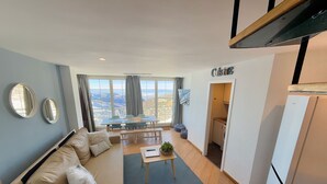 A modern living room with a sofa, coffee table, and dining area. - Inside Plaza Sierra Nevada (Monachil)
