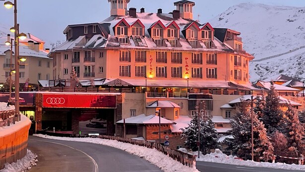 A hotel with multiple stories, a ski lift, and a mountain backdrop. - Inside Plaza Sierra Nevada (Monachil)