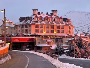 A hotel with multiple stories, a ski lift, and a mountain backdrop. - Inside Plaza Sierra Nevada (Monachil)