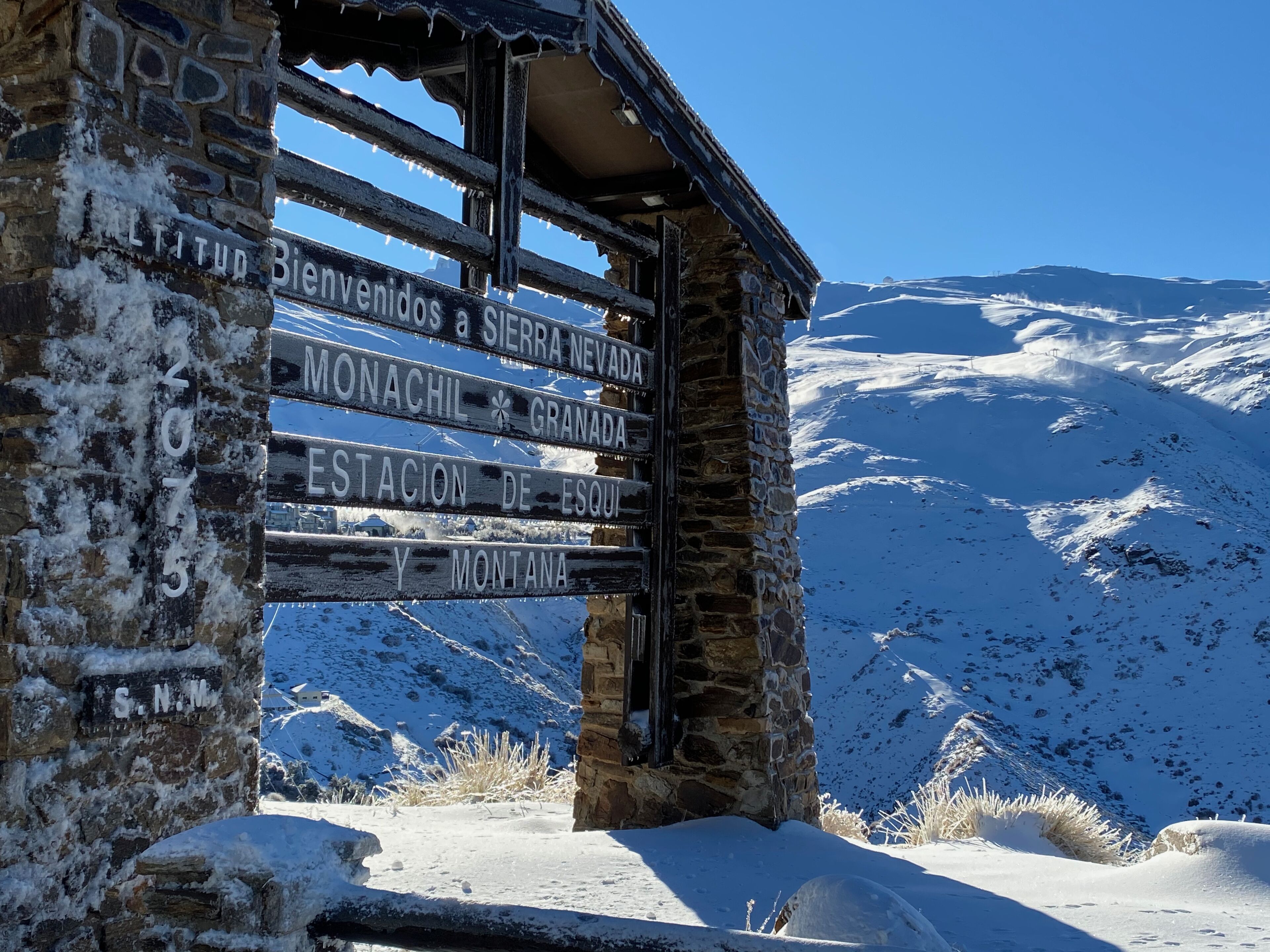 Een stenen constructie met een bord dat bezoekers verwelkomt in Sierra Nevada, Monachil, Granada en Montana.
