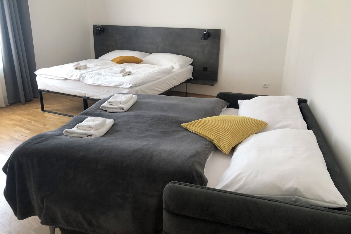 A hotel room with two beds, each with neatly folded towels and pillows.