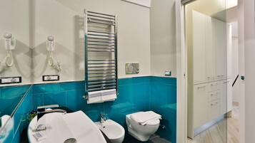 Un baño moderno con un lavamanos grande, un bidé y un perchero para toallas.