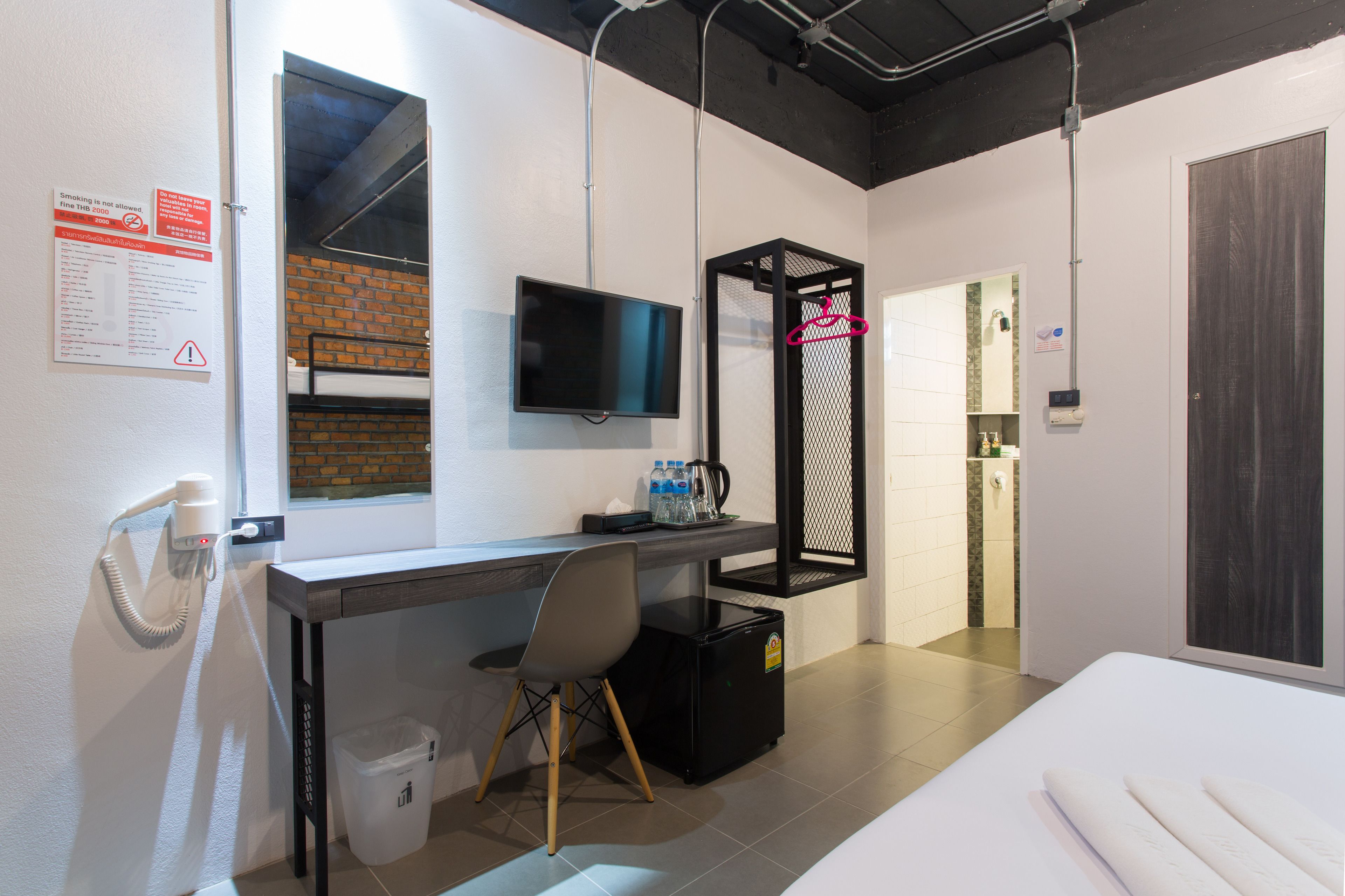 Una habitación de hotel con escritorio, silla, televisor y cama.