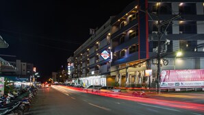 Un hôtel à plusieurs étages, doté d’une enseigne bien visible annonçant une offre spéciale pour les touristes.