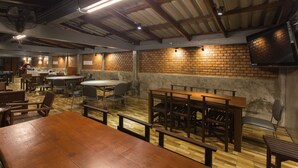 Un vaste espace de restauration intérieur avec des murs en briques, des tables et des chaises en bois.