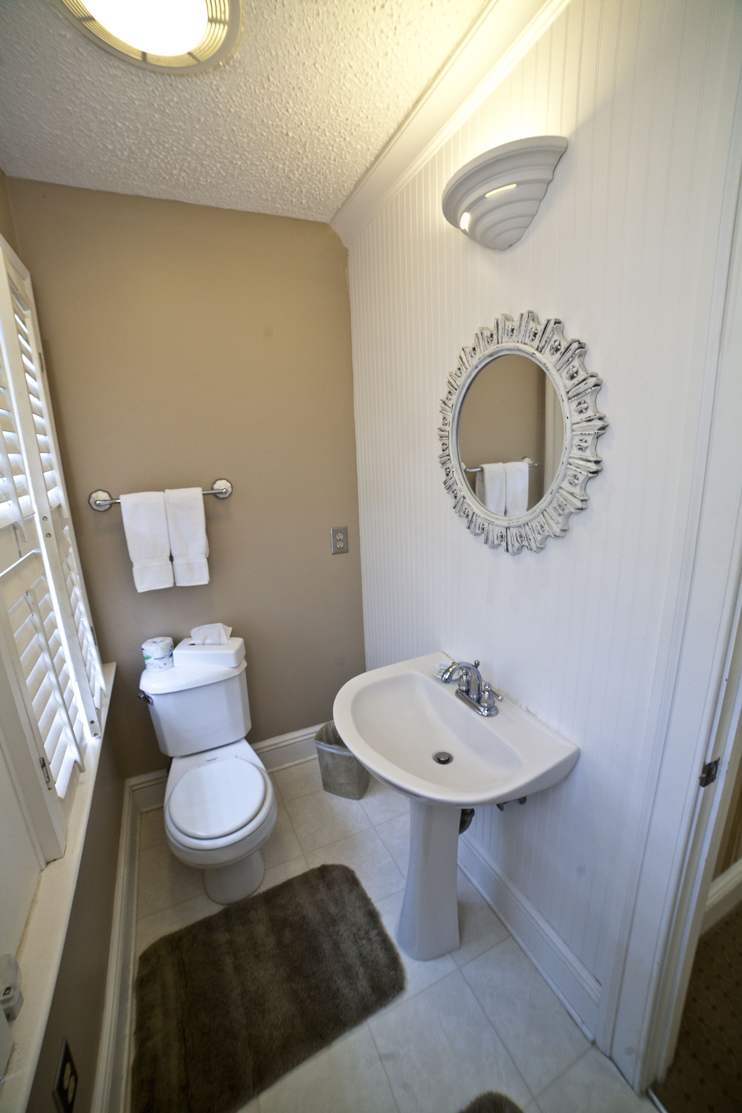 Ein Badezimmer mit Toilette, Waschbecken und Spiegel.