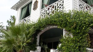 A white building with a balcony, a staircase, and a covered entrance. - Desoto Beach Bed & Breakfast (Tybee Island)
