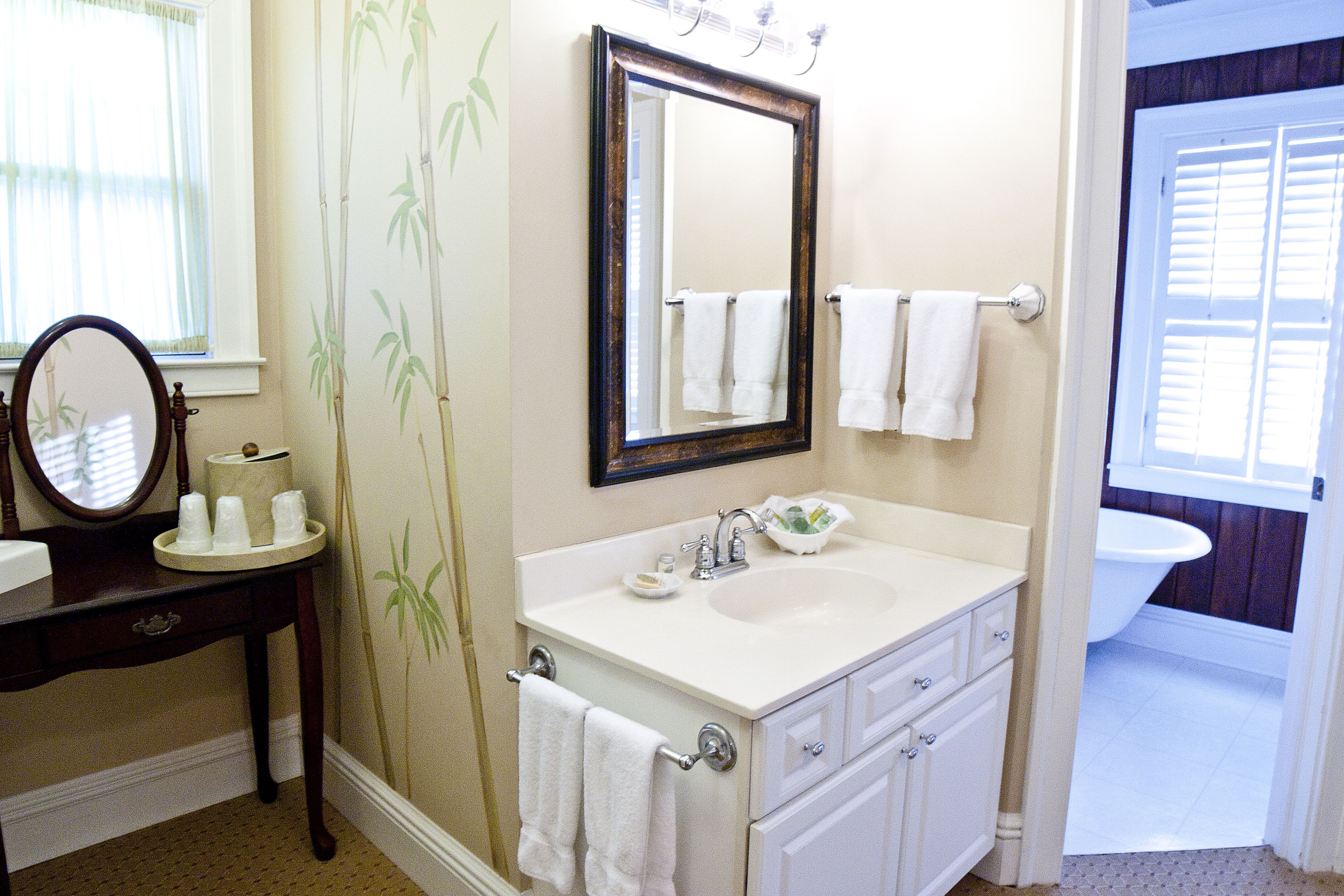 A bathroom with a sink, mirror, and towel rack.