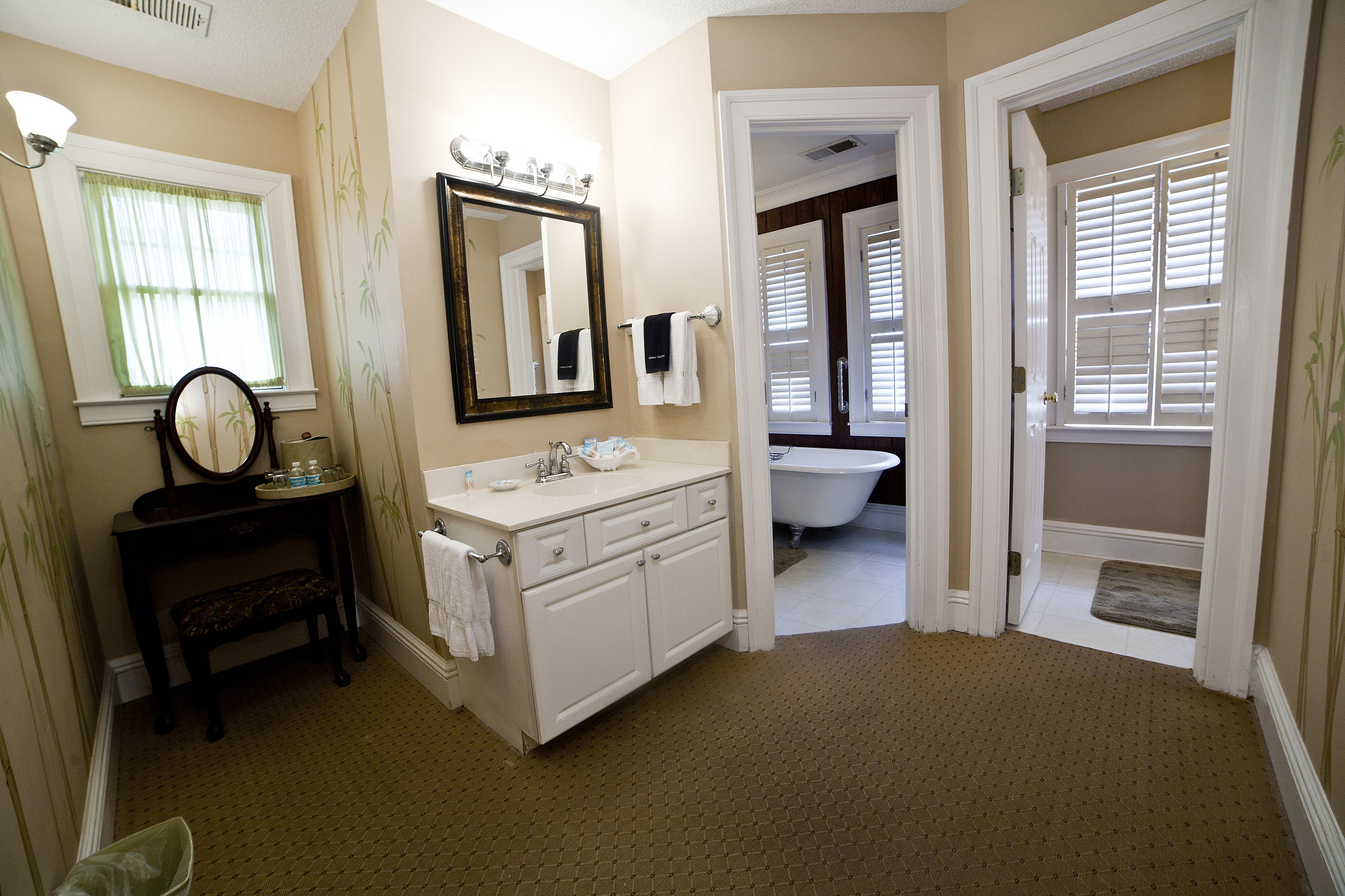 A bathroom with a sink, mirror, and a bathtub.