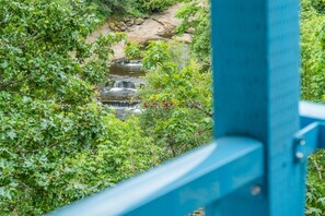 A view of a small waterfall surrounded by lush greenery, viewed from behind a blue structure. - Castaway Motel (Nanaimo)