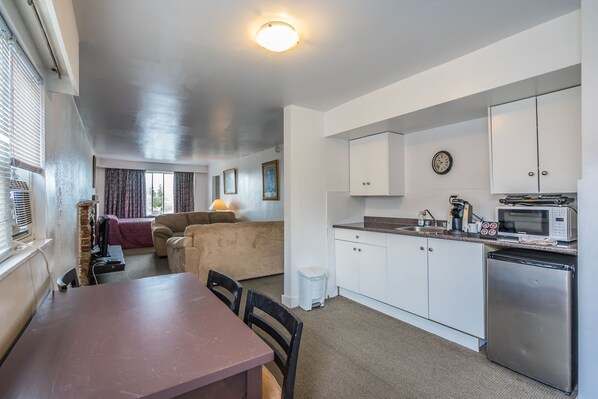 A compact living space with a dining area, kitchenette, and a cozy seating area.