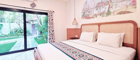 A bedroom with a large bed, a window with curtains, a wall-mounted air conditioner, and a painting.