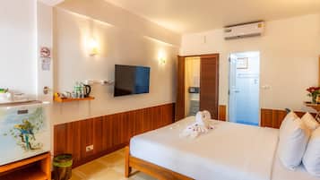 Une chambre d’hôtel équipée d’un lit, d’un téléviseur fixé au mur, d’un petit bureau avec un téléphone et d’une poubelle.