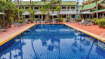 Una piscina al aire libre, sombrillas, sillones reclinables de piscina