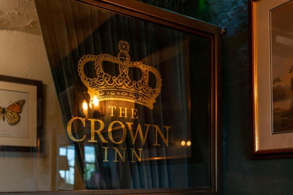 A framed sign with a crown and the text 'The Crown Inn.'