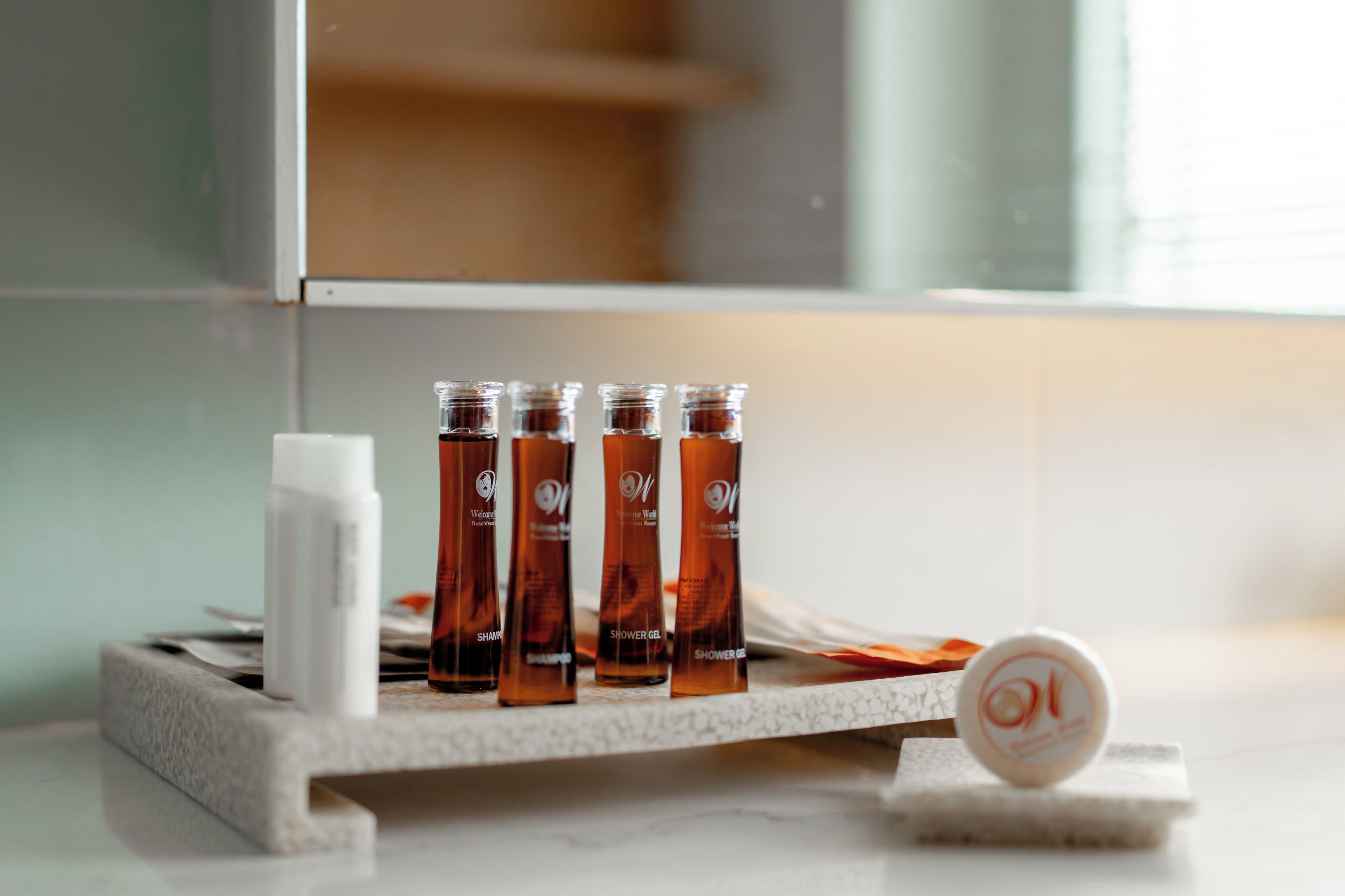 Ein Badezimmer-Waschtisch mit vier Duschgel-Flaschen und einer weißen Shampooflasche.