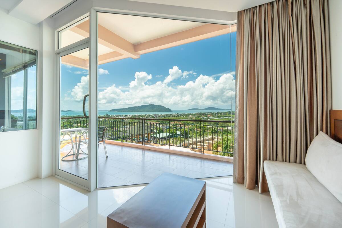 Un salon moderne avec un balcon, un canapé et une table.