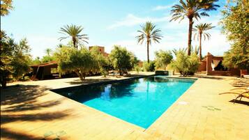 Alberca al aire libre y camastros