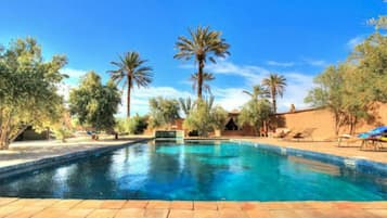 Una piscina al aire libre, sillones reclinables de piscina