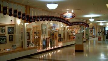 A shopping mall corridor with a Roger Man's store featuring a large illuminated sign.