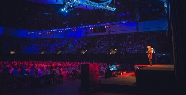 An indoor venue with tiered seating and a stage.
