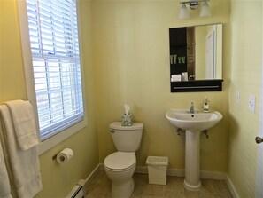 A bathroom with a toilet, sink, and window with blinds. - Atlantic Light Inn (Provincetown)