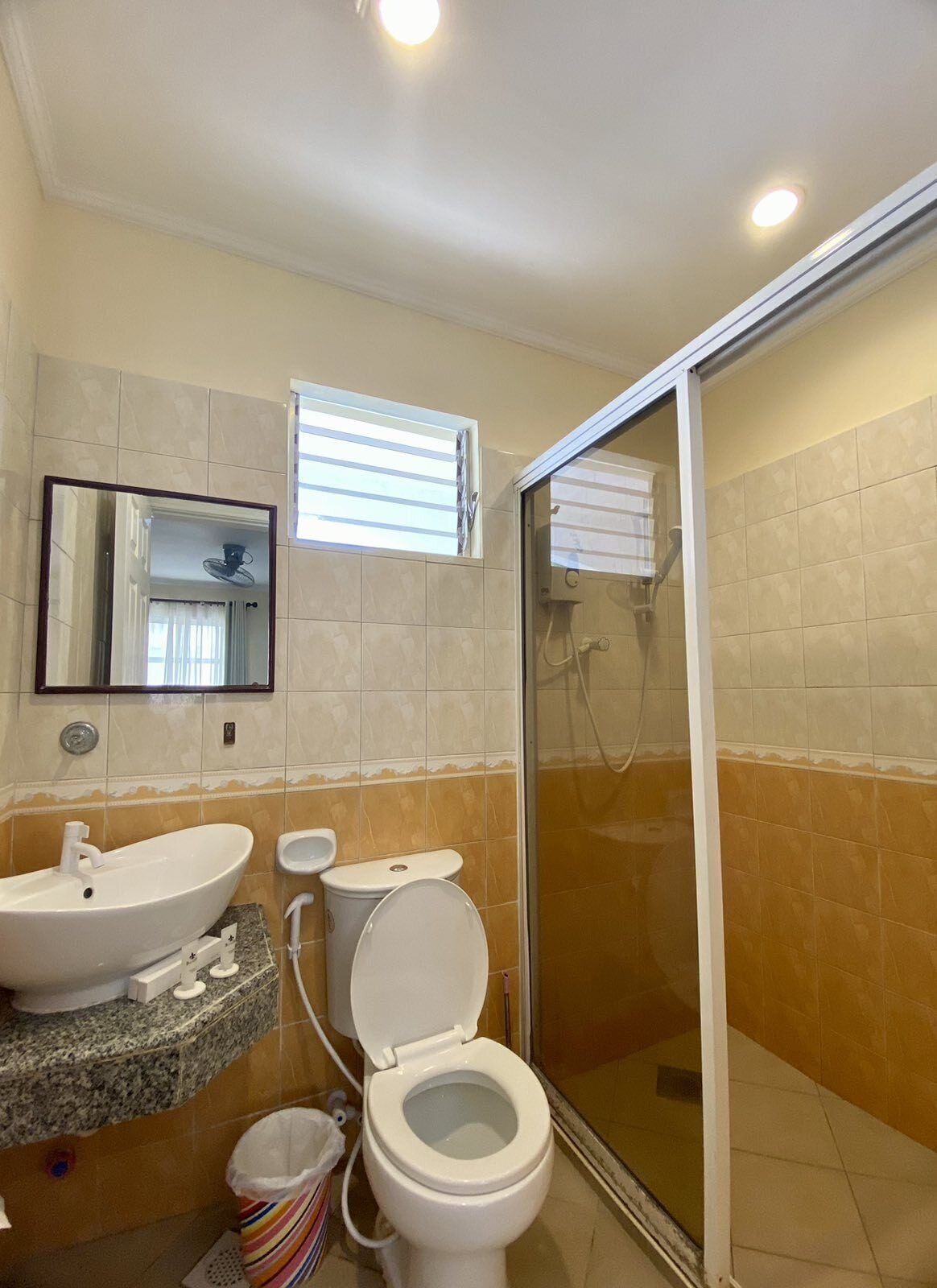 A bathroom with a sink, toilet, and shower.