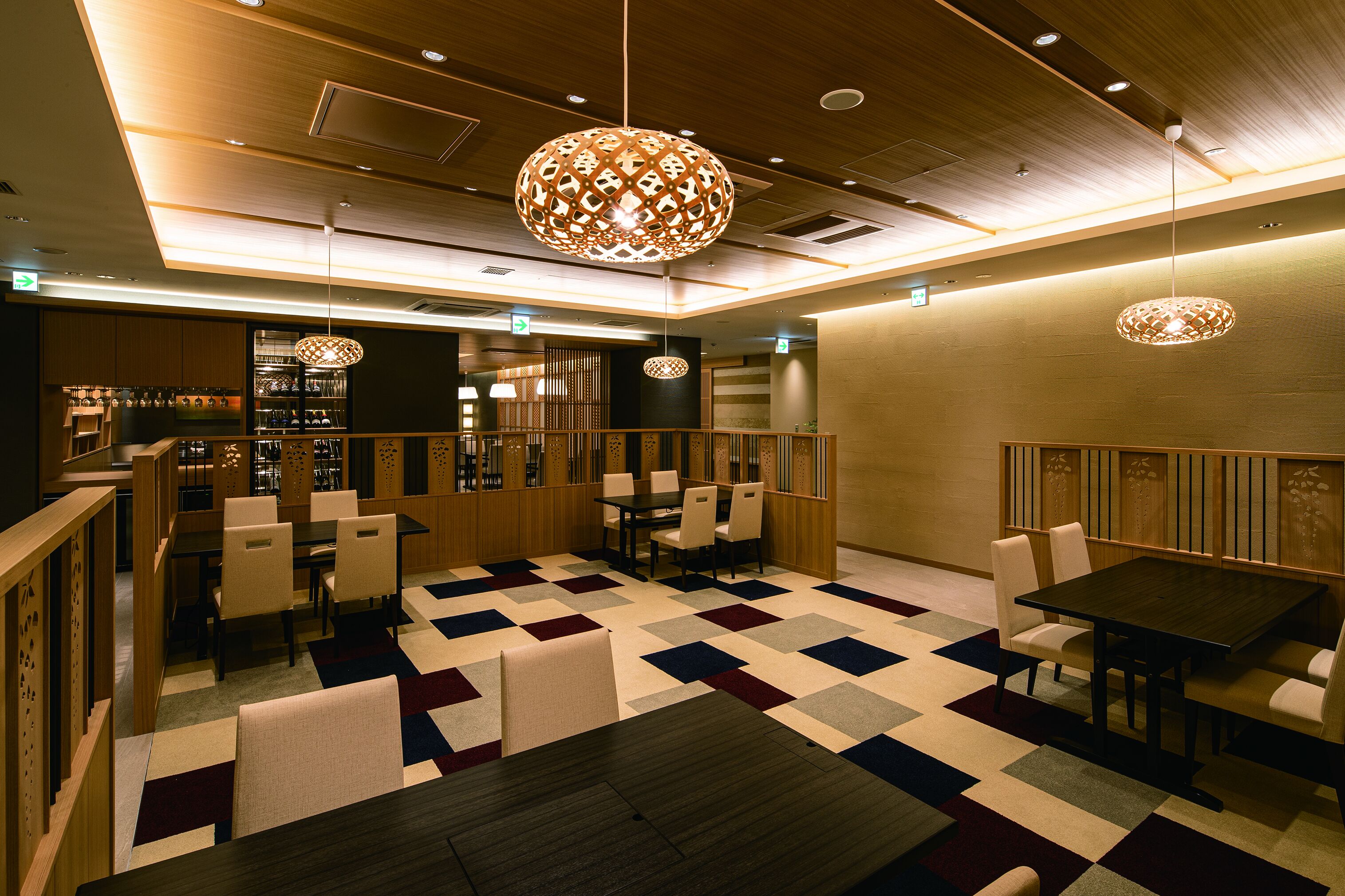 A restaurant with a checkered floor, wooden furniture, and hanging lamps.