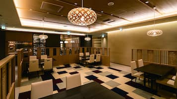 A restaurant with a checkered floor, wooden furniture, and hanging lamps.