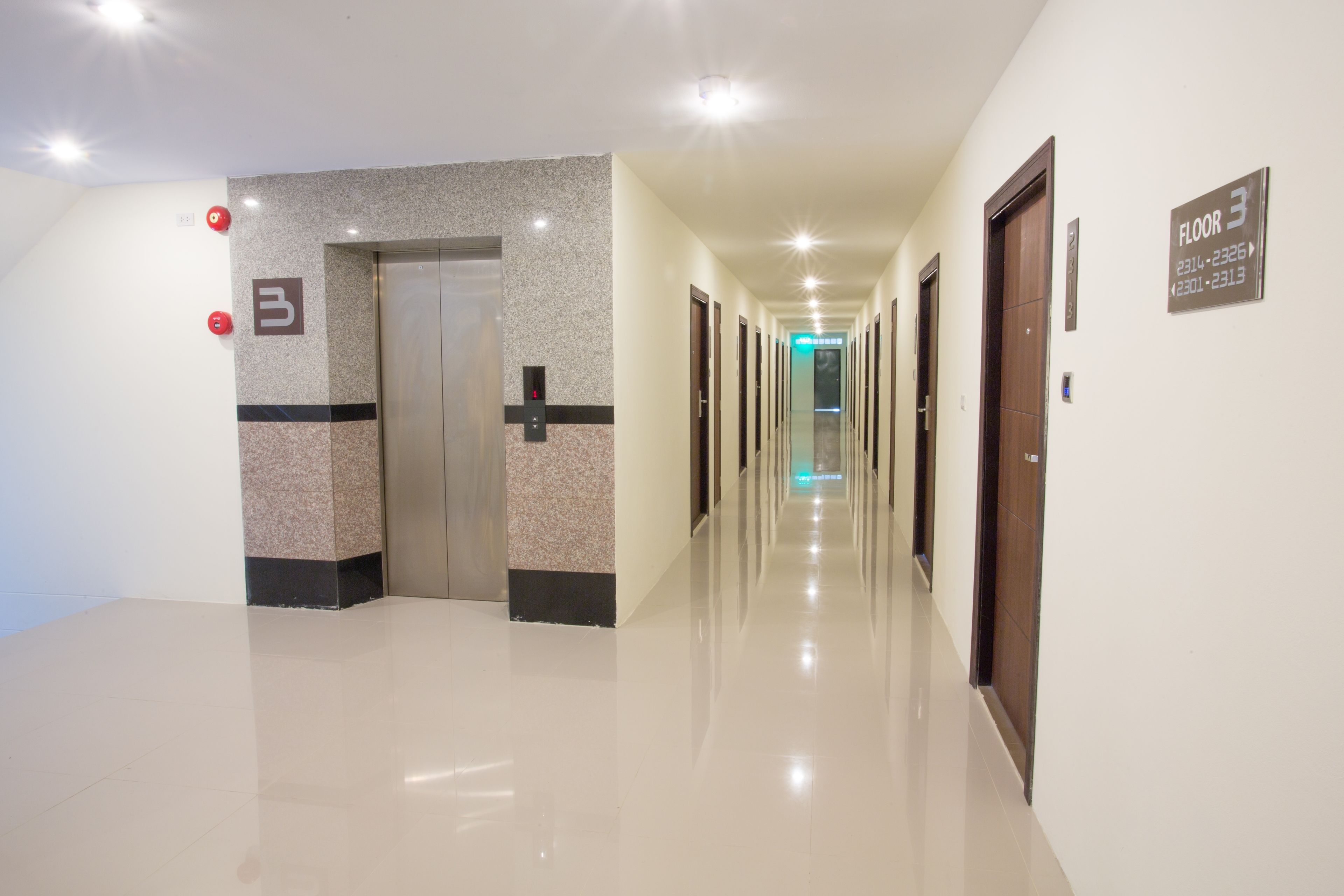 A clean, well-lit hallway with a polished floor, a visible elevator, and a sign indicating the location as Floor 3.