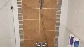 A shower with a handheld showerhead and a handheld faucet.