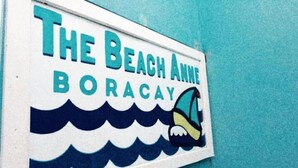 A sign with the text "The Beach Anne Boracay" and a wave graphic.