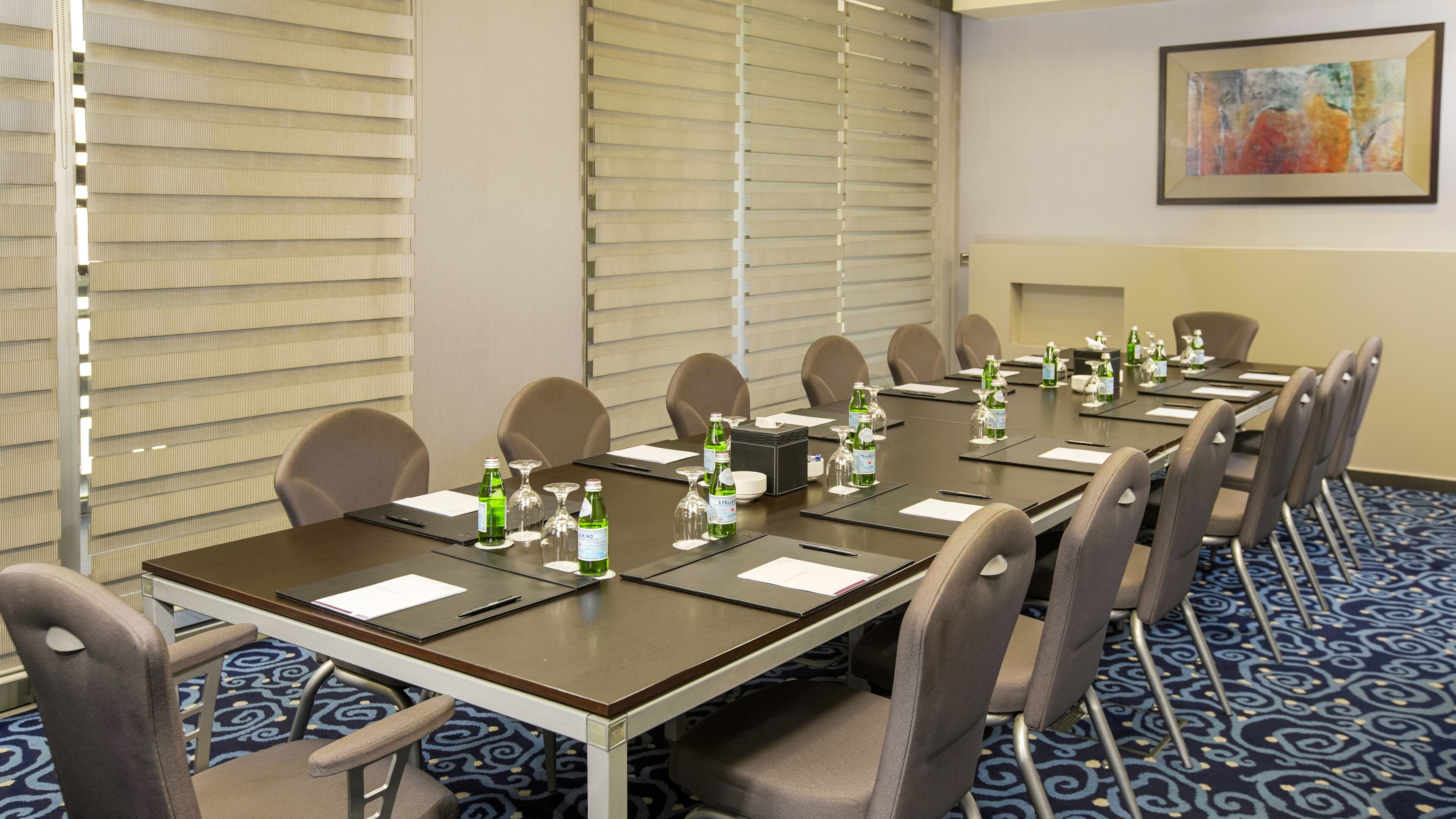 A conference room with a long table, chairs, and water bottles.