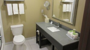 A bathroom with a toilet, sink, mirror, and towel rack. - Holiday Inn Express & Suites Butler by IHG (Butler)