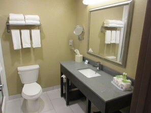 Een badkamer met toilet, wastafel, spiegel en handdoekhouder.