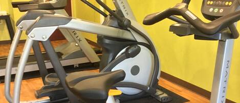 A fitness center with a Matrix brand elliptical machine, a treadmill, and a stationary bike.