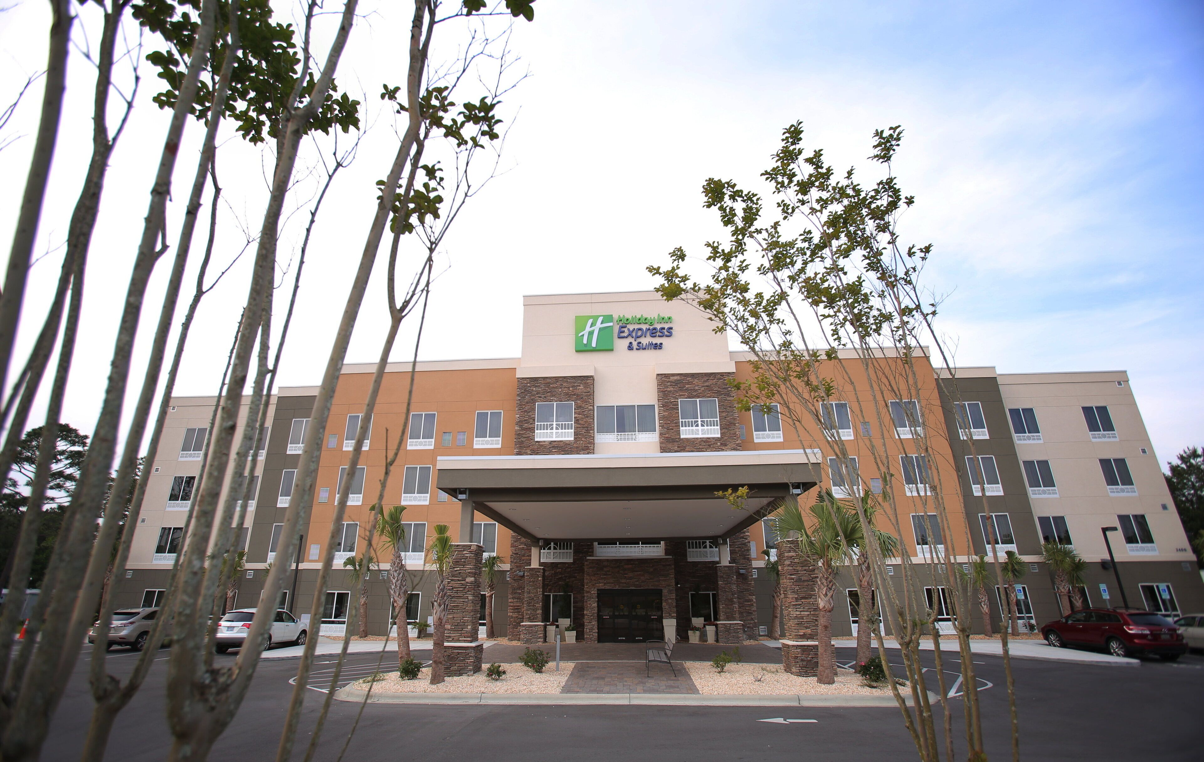 Ein mehrstöckiges Hotel mit auffälliger Beschilderung für Holiday Inn Express & Suites.