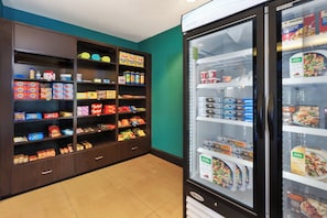A snack display with various packaged foods and a freezer section.