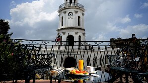 Una mesa de desayuno con alimentos y vistas a una torre de reloj histórica.
