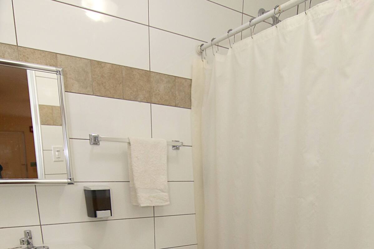 A bathroom with a white sink, toilet, and shower curtain.